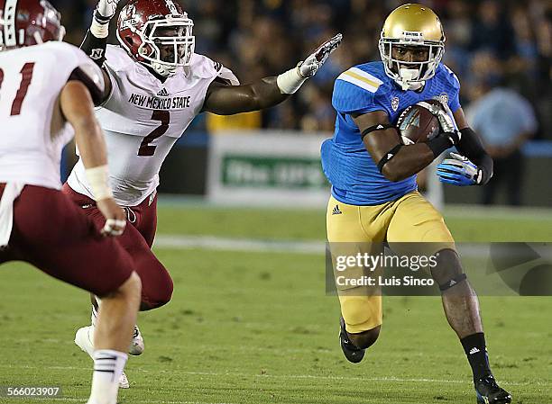 Wide receiver Devin Fuller gets a big gain after catching a pass from quarterback Brett Hundley against New Mexico State in the first quarter...