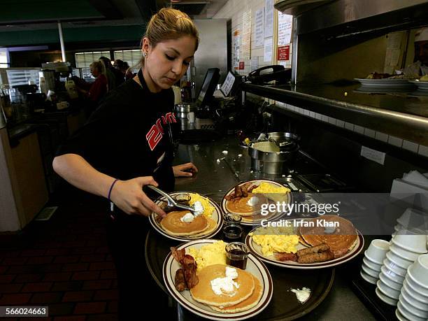 Gaby Estrella , prepares a tray of Grand Slam breakfast at Denny's Restaurant in Santa Ana on the morning of February 03, 2009. Competition among...