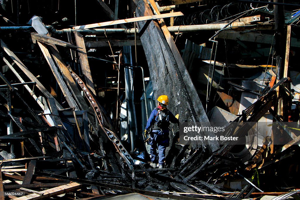 Search and Rescue teams sift through the charred debris of a metal works building in the 900 block