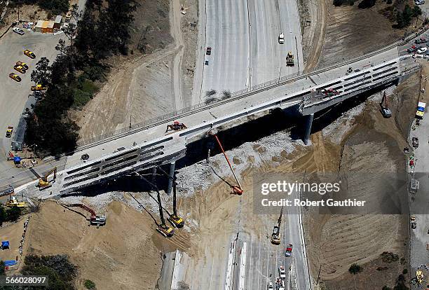 An aerial view of the empty 405 freeway as construction continues on the Mulholland bridge.