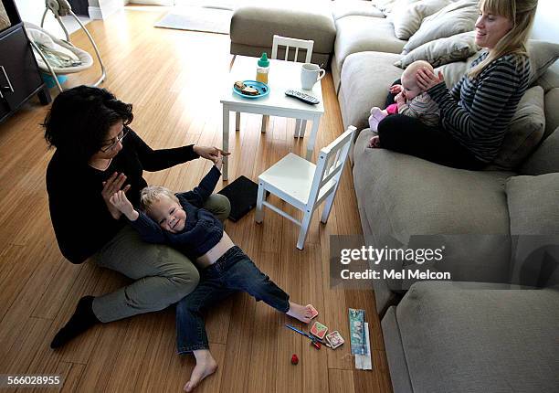 Left to rightNanny Blanca Duarte Julian Moggach his sister Charlotte Moggach, 7 months, and mother Samantha Slattery gather inside the den during...