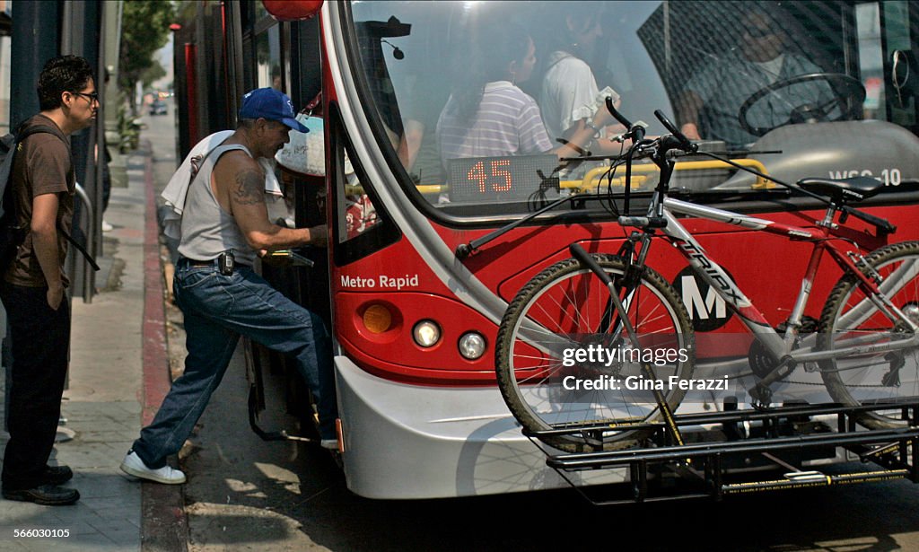Bus Stop Riders Bus riders board a Metro Rapid bus at the Wilshire and Western bus ...