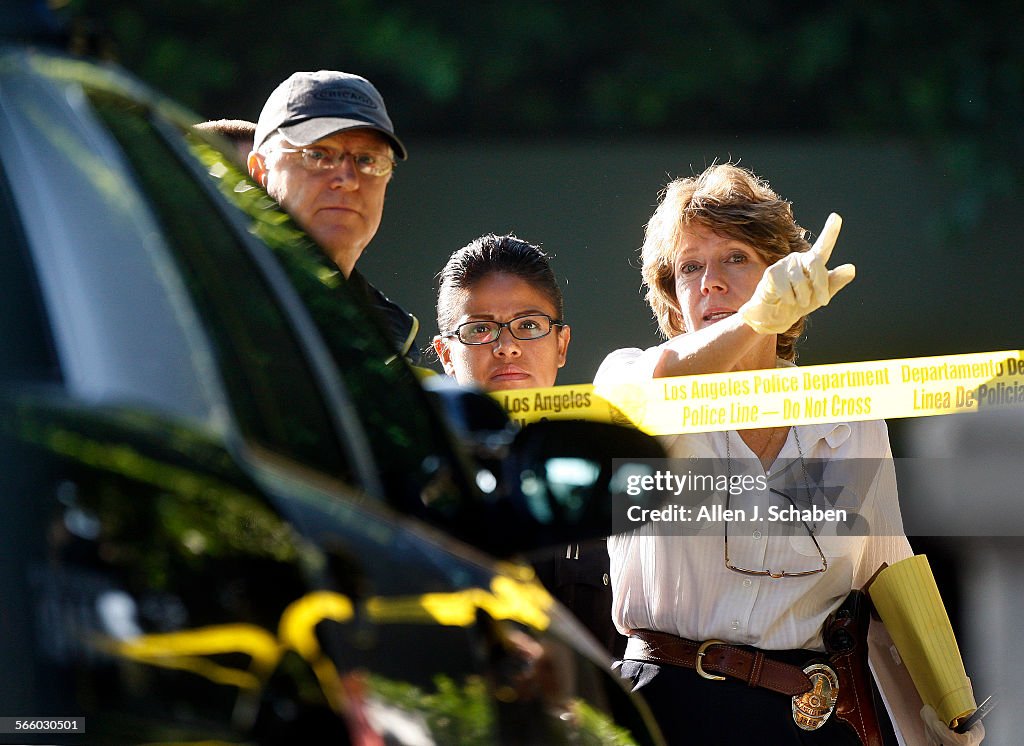 Los Angeles Police Dept. investigators view the shooting scene where a sword-weilding man was shot