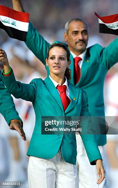 Iraqi sprinter Dana Abdulrazak waves her countries flag during opening ceremonies in the 2008 Beijing Olympics.