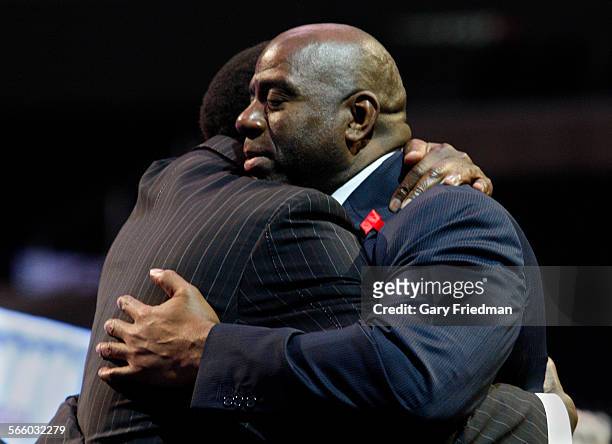 Ervin "Magic" Johnson is hugged by former player A.C. Green after Magic spoke to friends and the media at a news conference on the 20th anniversary...