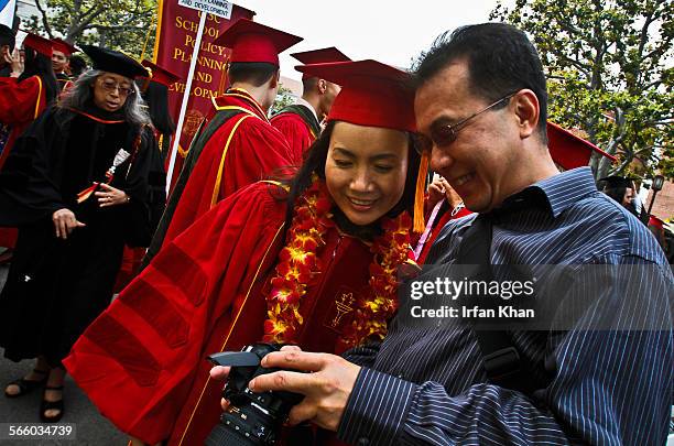 Kim Chi Nguyen, left, looks at the photos her husband Tri Ha took of her at the graduation ceremony held on Friday, May 14, 2010 at USC in Los...