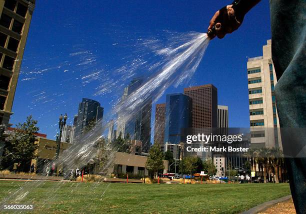 Sal Martinez waters the newly planted sod at the LAPD headquarters building in downtown Los Angeles July 14, 2010.