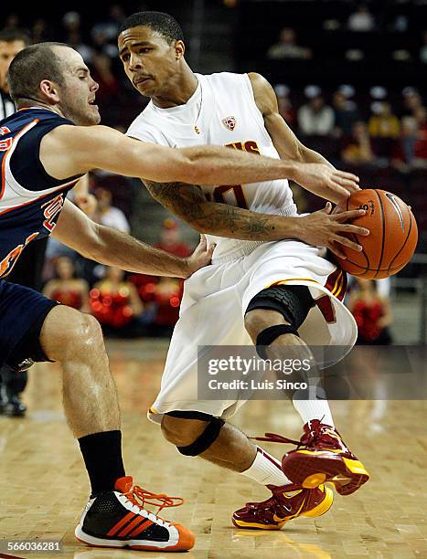 Point guard Maurice Jones drives to the basket as Fullerton's Perry Webester defends in the first half Wednesday, Nov. 24 at Galen Center in Los...