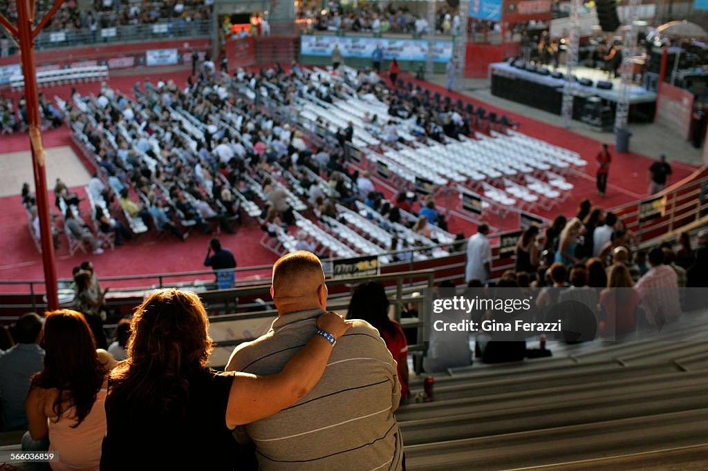 Pico Rivera residents sit in the warm setting sun to enjoy the Three Midniters band during Arena Ja