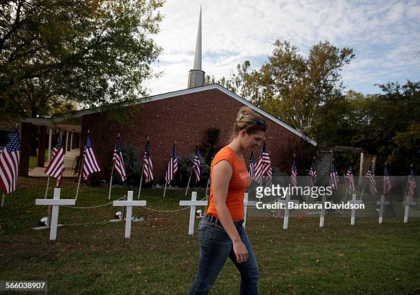 Ashley Norris walks away from a temporary memorial site setup in front of the Central Christian Church in memory of those killed and wounded at Fort...