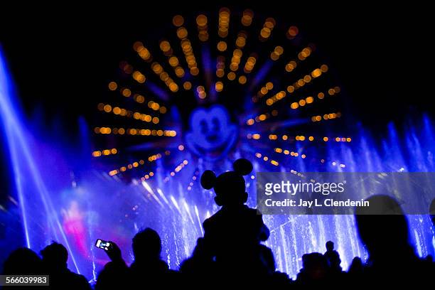 Child and his Mickey Mouse ears are silohuetted against the World of Color nightly light and water show at Disney California Adventure Park Feb. 2,...