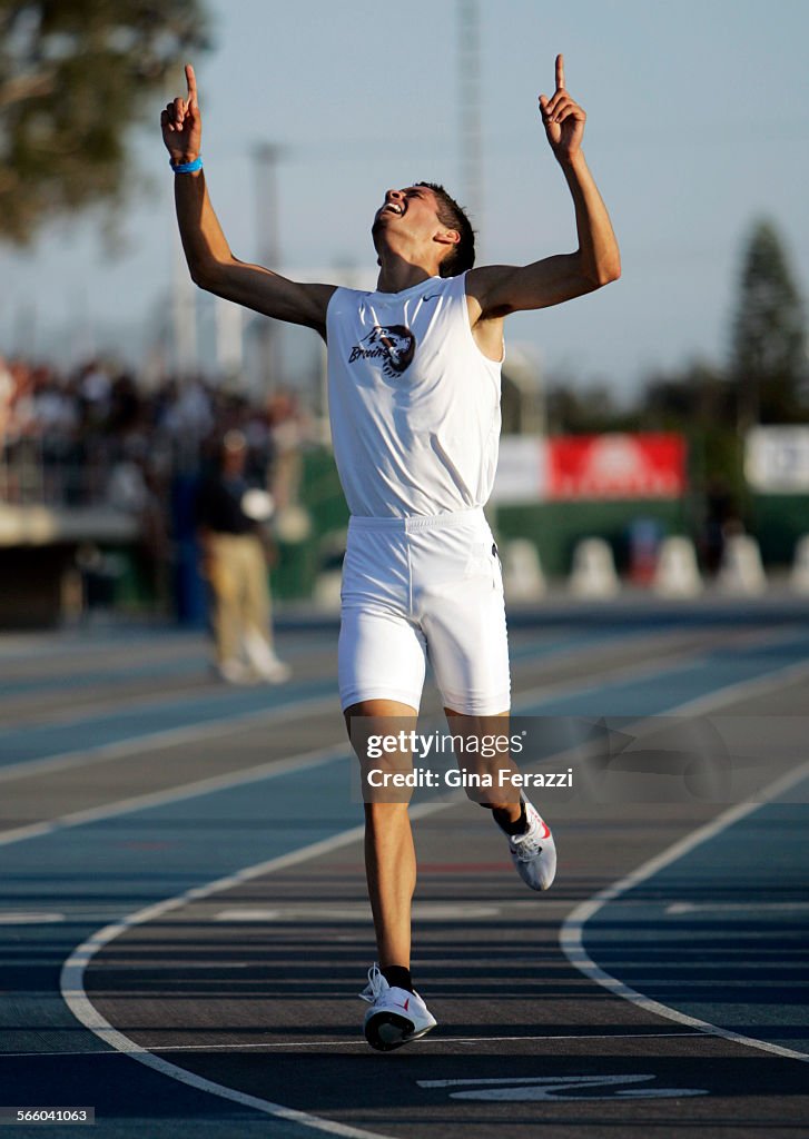 Riverbank's German Fernandez points to the sky as he crosses the finish line in the boys 3200 meter