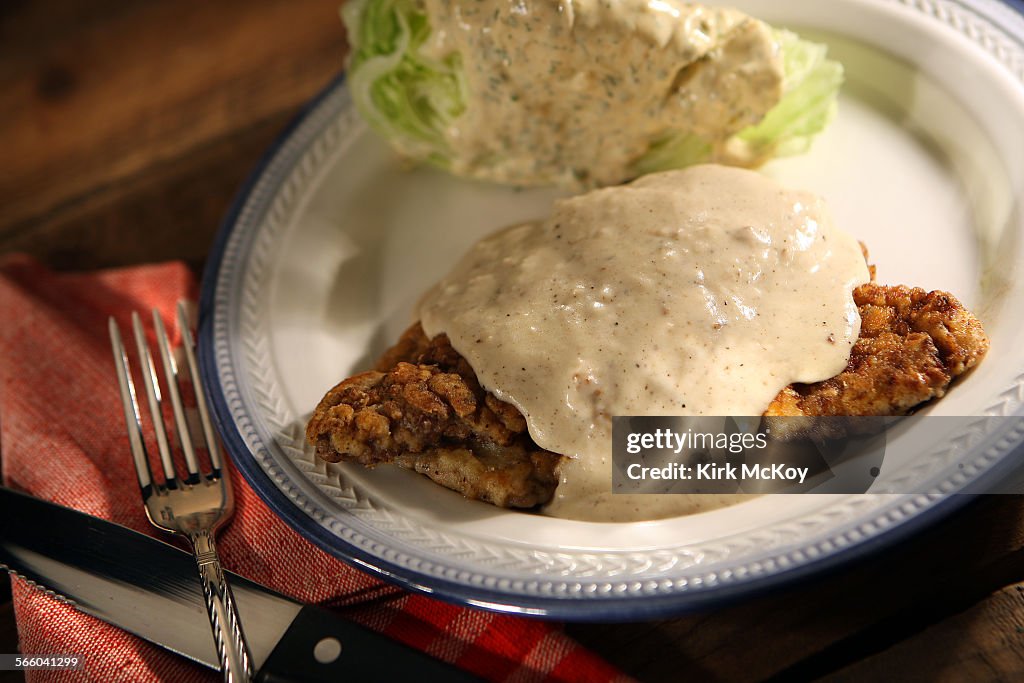 Pioneer Woman: A plate of Chicken fried Steak with gravy and a wedge of iceberg lettuce with homema