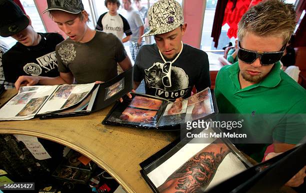 Norway residents Remi Henriksen, 3rd from left, and Frederek Leithe, far right, along with other members of their traveling group, look at portfolios...