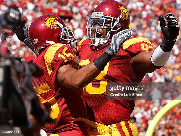 Cornerback Kevin Thomas is congratulated by teammate Everson griffen after returning an interception of a Rudy Carpenter pass for a touchdown against...