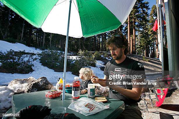 Budgetminded snowboarder Ryan Groat and son Luka of Huntington Beach make turkey sandwiches while parked in the lot near chair 2 at Mammoth Mountain...
