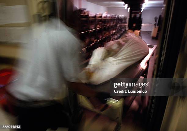 Attendant wheels body into room at the Los Angeles county morgue where coroner officials were preparing for an autopsy on Feburary 20, 2009.
