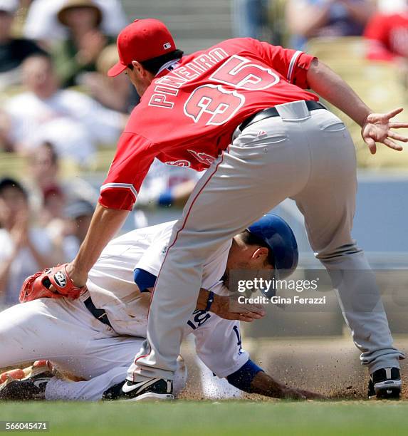 Dodgers Jamey Carroll slides safely into home after Angels pitcher Joel Pineiro threw a wild pitch in the second inning at Dodger Stadium.