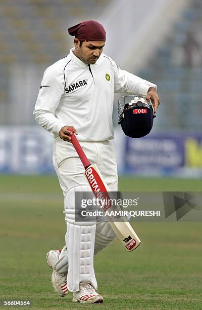 Indian batsman Virender Sehwag walks back to the pavillion after his dismissal by Pakistani bowler Naved-ul-Hasan for 254 runs during the fifth and...