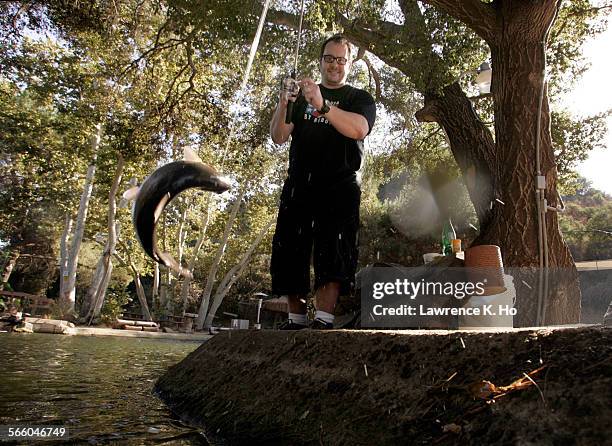 Tony Lovett pulls a rainbow trout from the water. Lovett, author of L.A. Bizarro fishing on Sep. 25, 2009 at Trout Dale, a man-made concrete fishing...