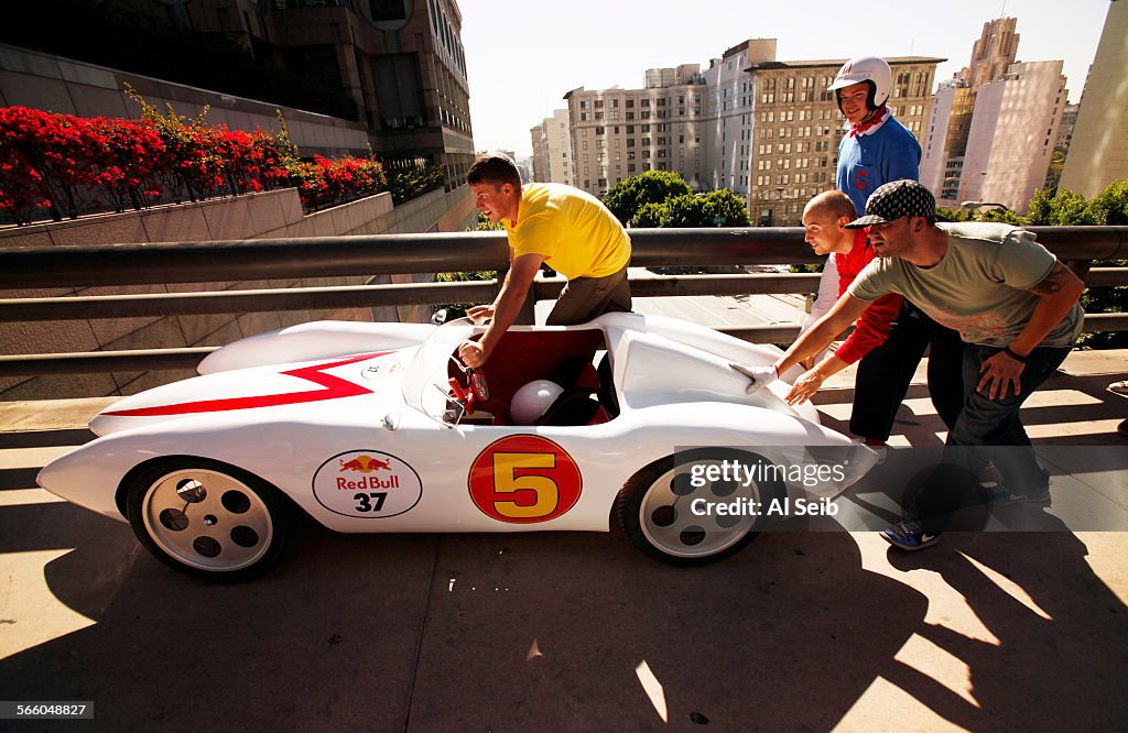 The Speed Racer Team pushes their handmade soapbox racer back up Grand Avenue after a test run dow