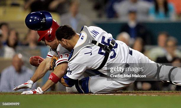 Chris Coste of the Philadelphia Phillies slides safely into home plate ahead of the tag by Los Angeles Dodgers catcher Russell Martin to give the...