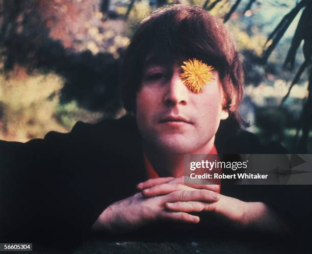 Beatles singer, songwriter and guitarist John Lennon . He has a dandelion covering his left eye, 1966.