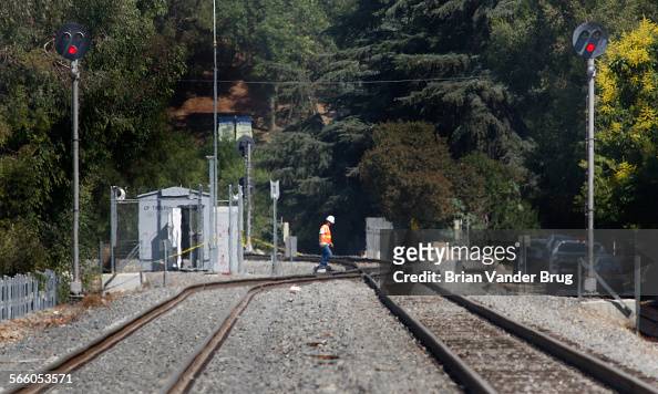 A railway worker walks across the track switch between two red signals near Nashville St. in Chatsw