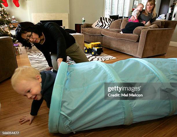 Left to rightJulian Moggach his nanny Blanca Duarte sister Charlotte, 7 months, and mother Samantha Slattery hang out inside the living room of...