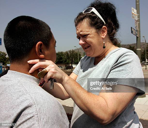 Nearby resident Heidi Vankempen who was on the crash scene last night comforts Niko Medonza 17 and other Eagle Rock High School classmates as they...