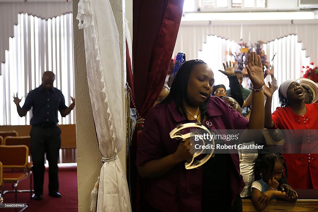 Parishioners and visitors sing during a Sunday service at the Full Gospel Apostolic Church of God/L
