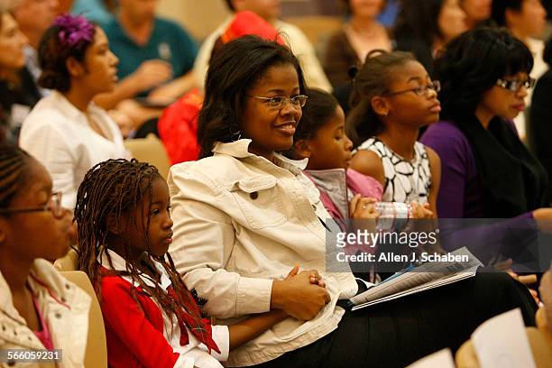 Beneca Ward, center, of Culver City, clutches hands with Kennedy Clement left, and daughters, Alani Wilson closest to her, and Aaliyah Wilson and...