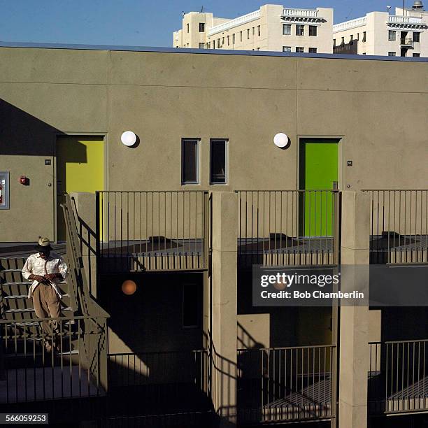 Resident of the "Abby" walks down to the patio of his building as the "Weingarten" building rises in the background. The "Rainbow" and the "Abby" are...