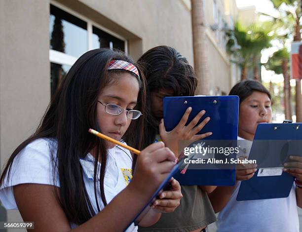 Garfield Elementary fifth grade students Lesley Maldonado left, Daniela Manjarrez center, and Areli Hernandez right, make notes of graffitti,...