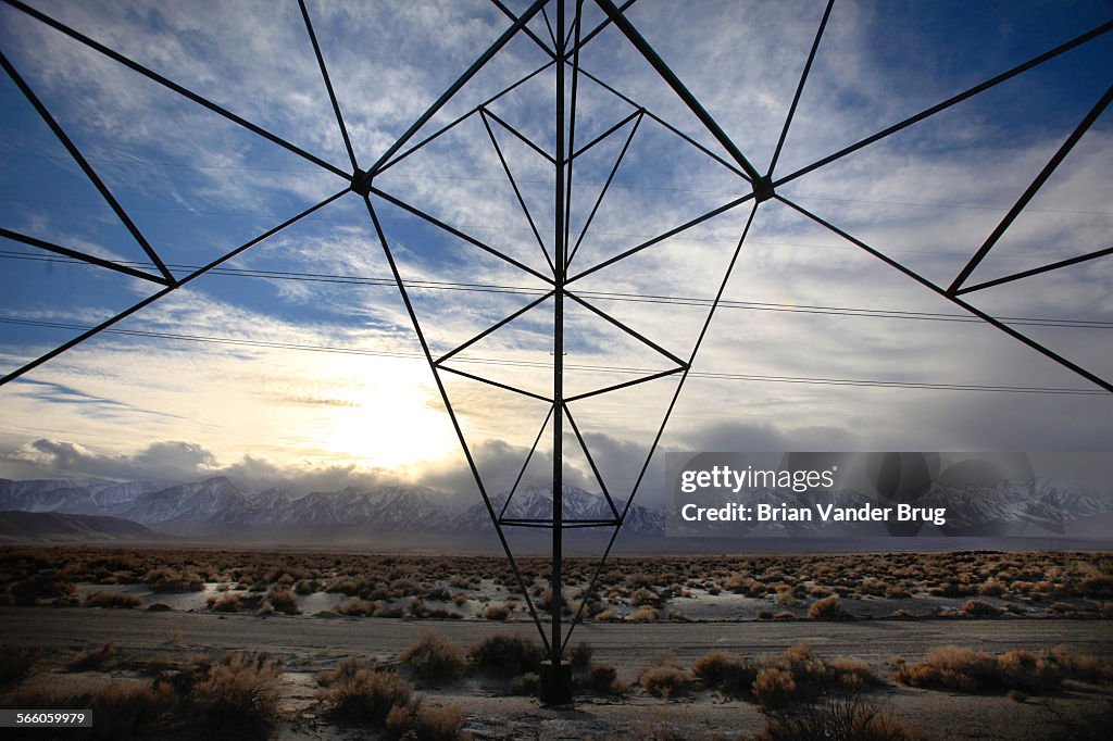 Transmission towers line an access road east of the Lower Owens River in a view west towards the Si