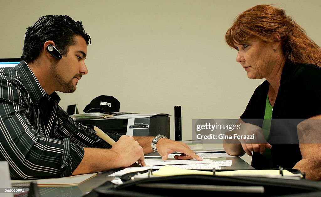 CEO Suzanne DeRossett looks over client contracts with her son, company Vice President John DeRosse