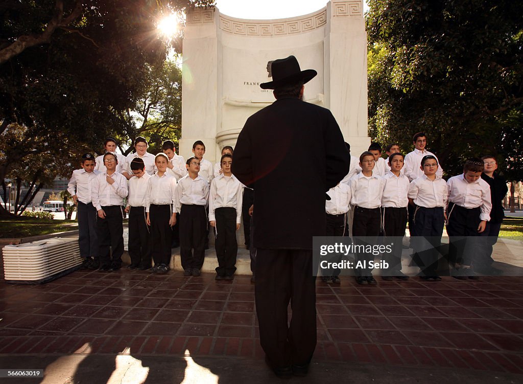 Rabbi Leibel Cohen, center, the choir director of Cheder Menachem Elementary School works with the
