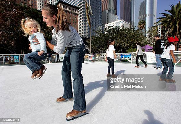 Siena Meyer is lifted up into the air by her mother Gina, while taking to the ice after the grand opening ceremony for Downtown On Ice, an outdoor...