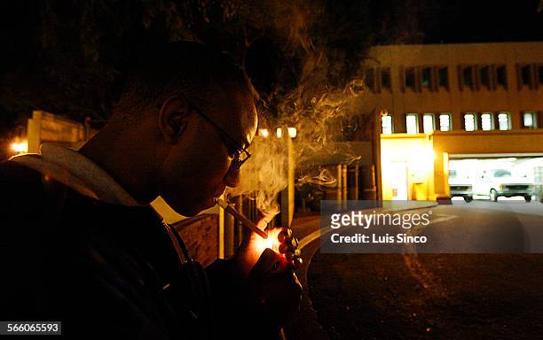 Marine Corps reserve Cpl. Derrek Williams, of Marietta, Ga., takes a smoke break from working at the Los Angeles County Coroner's morgue in Boyle...