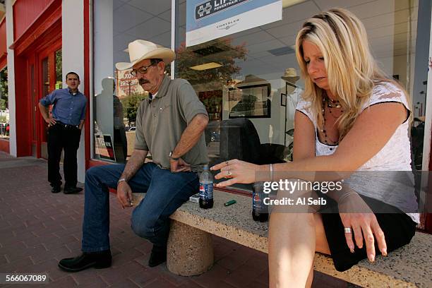Michelle Arnold Sales Manager for San Joaquin Dodge in Taft sits with Jim Baird in front of the dealership that may have to close its doors soon...
