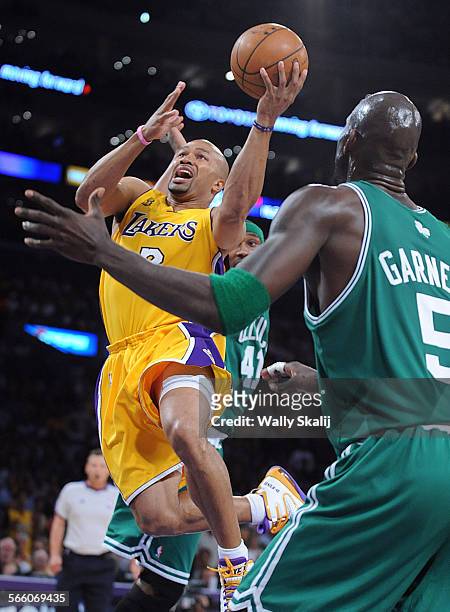 Lakers Derek Fisher threads between the Boston Celtics James Posey and Kevin Garnett to the basket in the second quarter in game four in the NBA...