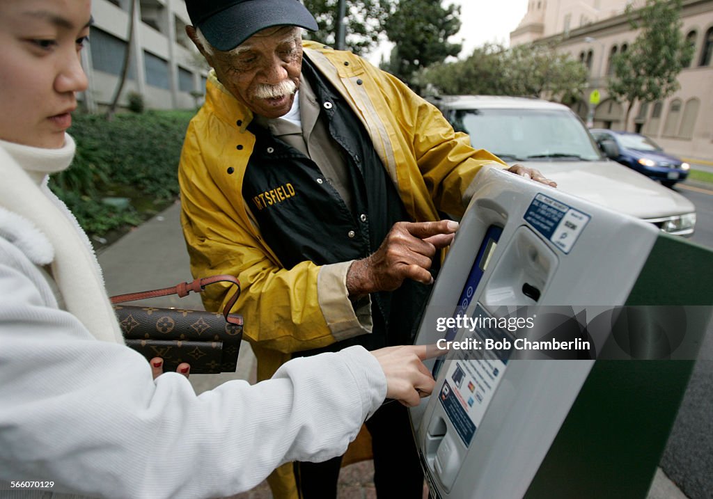 Los Angeles Parking Officer William Hartsfield helps USC student Christina Park, 23, use new pay st