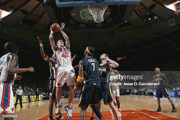David Lee of the New York Knicks reaches for the basket under pressure from Jermaine O'Neal of the Indiana Pacers on December 17, 2005 at Madison...