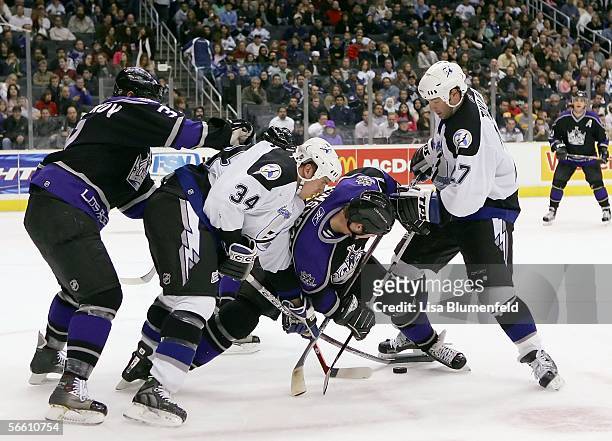 Ryan Craig and Tim Taylor of the Tampa Bay Lightning battle for possession against Derek Armstrong of the Los Angeles Kings on January 17, 2006 at...