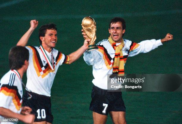 Lothar Matthaeus and Pierre Littbarski of Germany celebrates with the trophy after winning the World Cup final match between Argentina and Germany at...