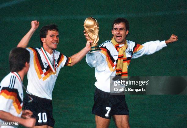 Lothar Matthaeus and Pierre Littbarski of Germany celebrates with the trophy after winning the World Cup final match between Argentina and Germany at...