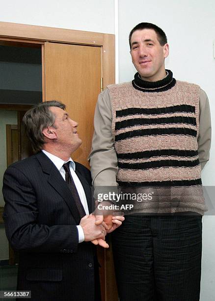 Ukraine's President Viktor Yushchenko looks at Leonid Stadnik believed to be the tallest man in the world during their meeting at a hospital in Kiev,...