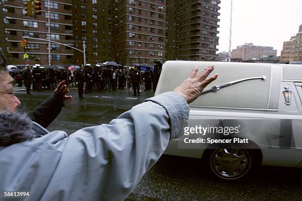 Woman waves at the hearse carrying the body of Nixzmary Brown after her funeral January 18, 2006 in New York City. Brown was found beaten to death...