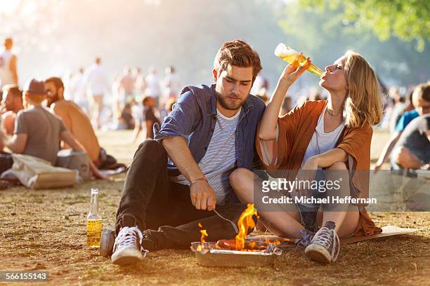 couple in park using barbecue - drinking bier stock-fotos und bilder