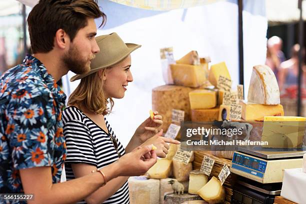 couple in market at cheese stall - white cheese stock pictures, royalty-free photos & images